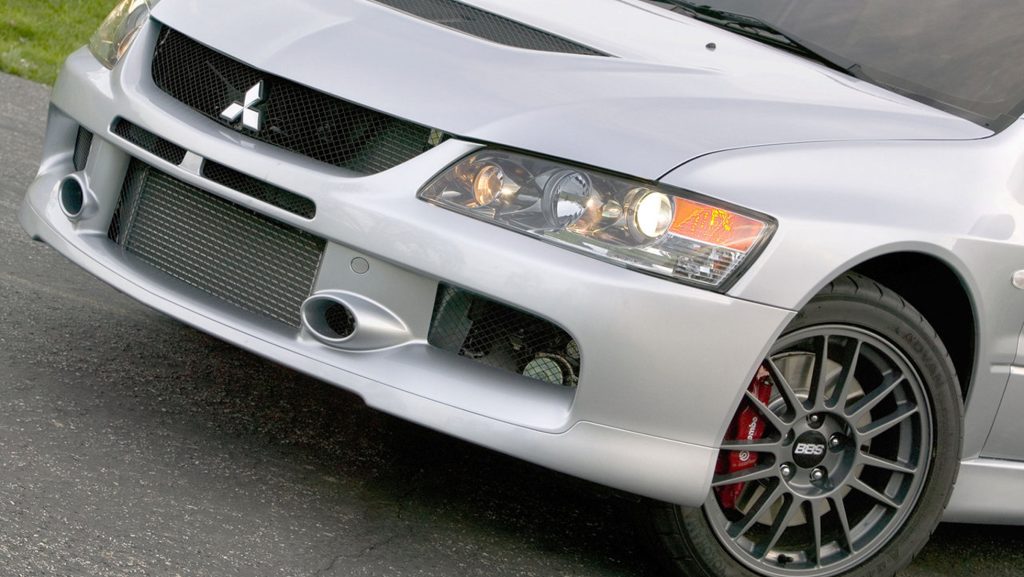Front end close up of silver Mitsubishi Lancer Evolution showing aggressive bumper design, intercooler and BBS wheels